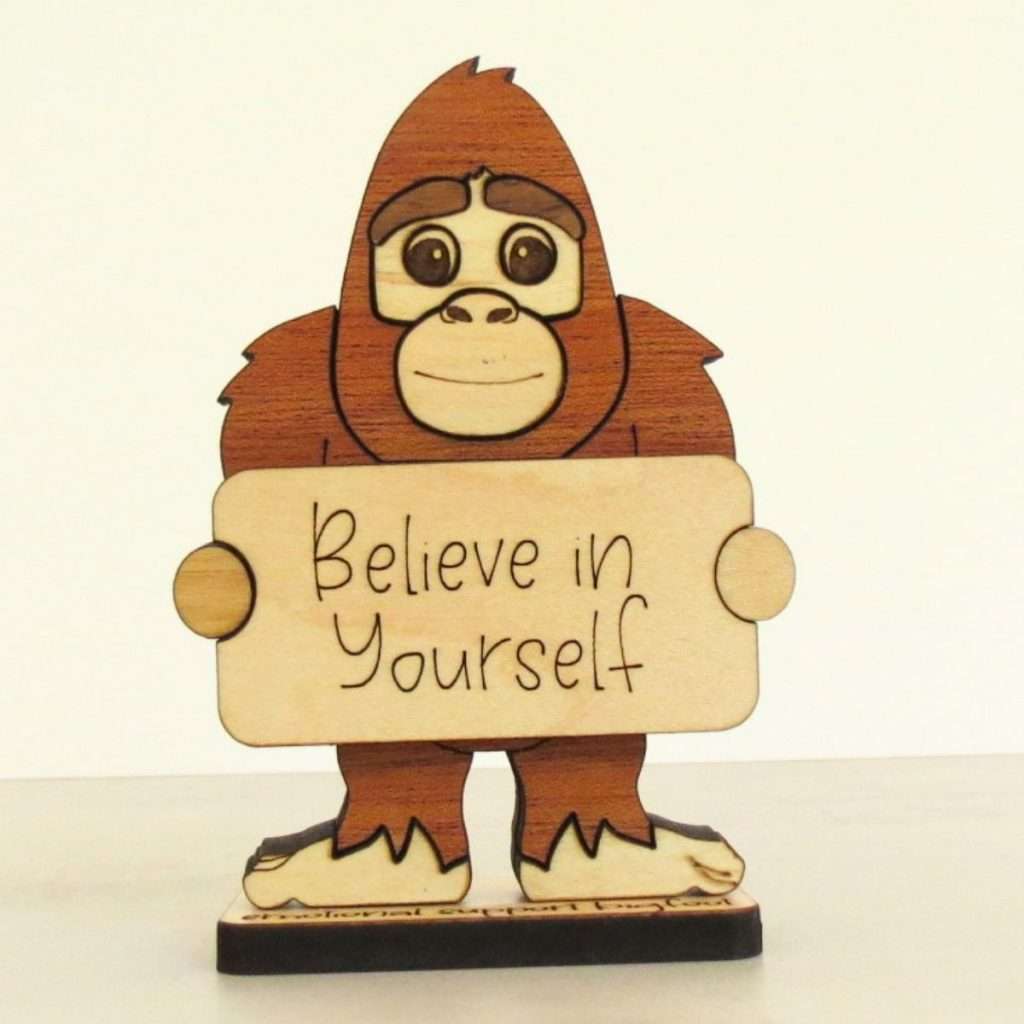 Handcrafted hardwood emotional support bigfoot desk pet holding sign that reads Believe in Yourself