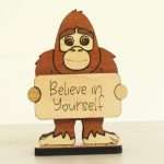 Handcrafted hardwood emotional support bigfoot desk pet holding sign that reads Believe in Yourself