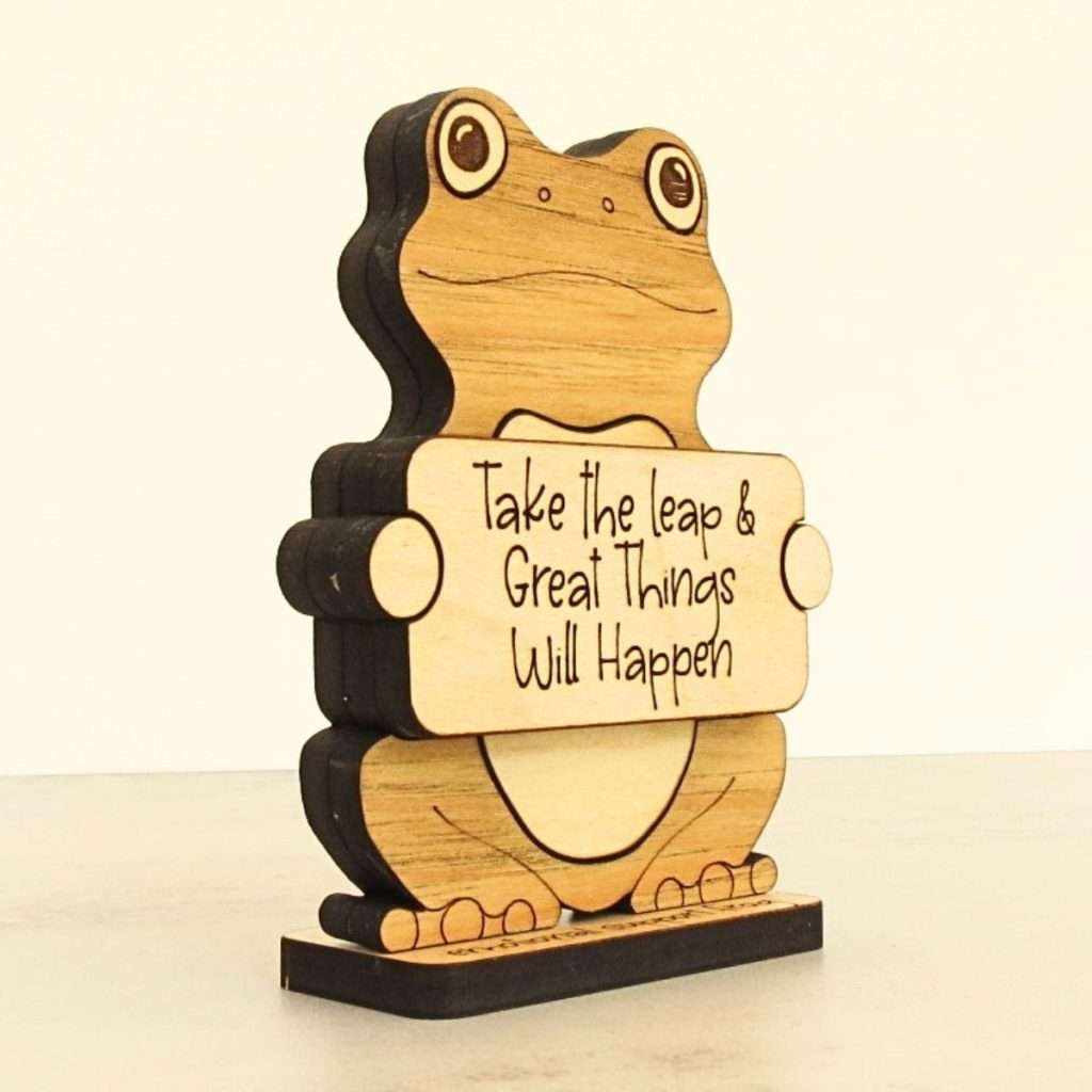 Angled view of layered hardwood emotional support frog showing wood species detail and construction