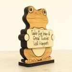 Angled view of layered hardwood emotional support frog showing wood species detail and construction