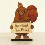 Handcrafted hardwood emotional support rooster desk pet holding sign that reads Born Loud Stay Proud