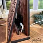 Side view of wood book stand showing the hidden storage compartment to keep cell phone in while charging. Cables run through the back of the stand, hidden from view but convenient to access.