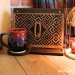Geometric monogram book stand, shown in the dar stain and leather combination with the letter Q cutout in a styled scene with an attractive handmade coffee mug.