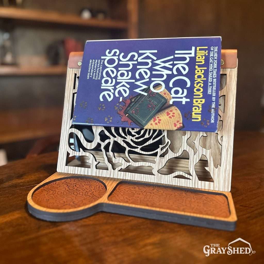 The rose design front book stand in use as a bookmark with a book positioned over it.